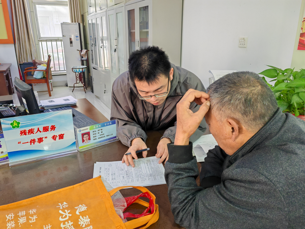 图为村(社区)残协专职委员为残疾人及亲属提供帮办代办服务